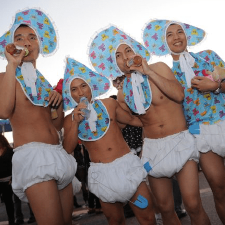 Hommes déguisés en bébé lors d'un jeu organisé pour une daddy shower